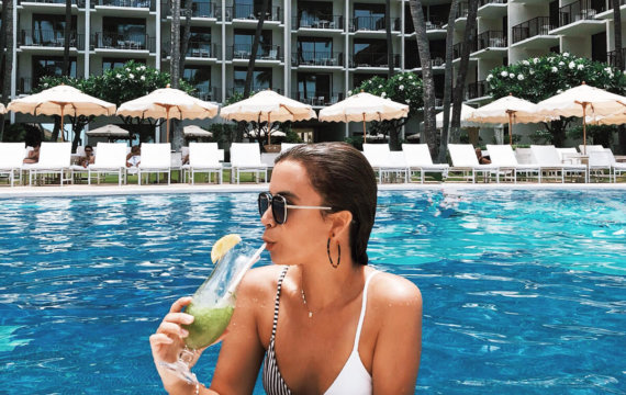 Woman enjoying a cocktail at the Halekulani pool
