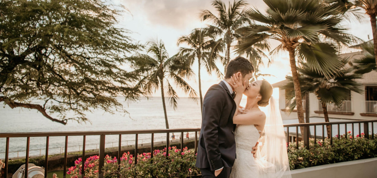 Wedding couple share a kiss at sunset