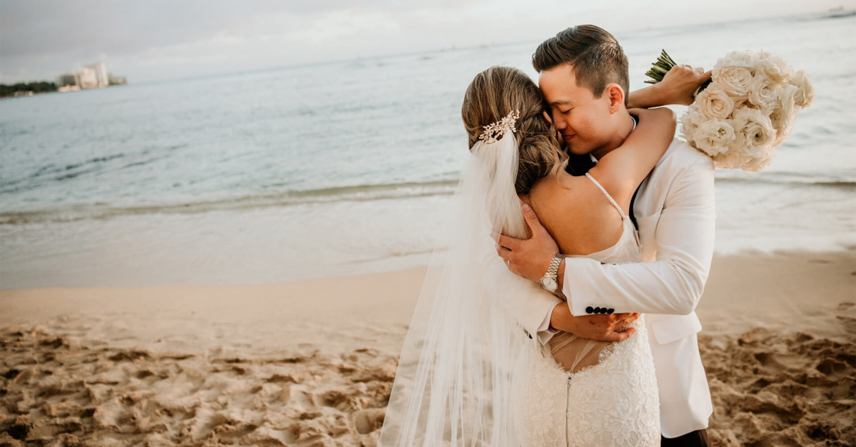 Wedding couple embrace on the beach