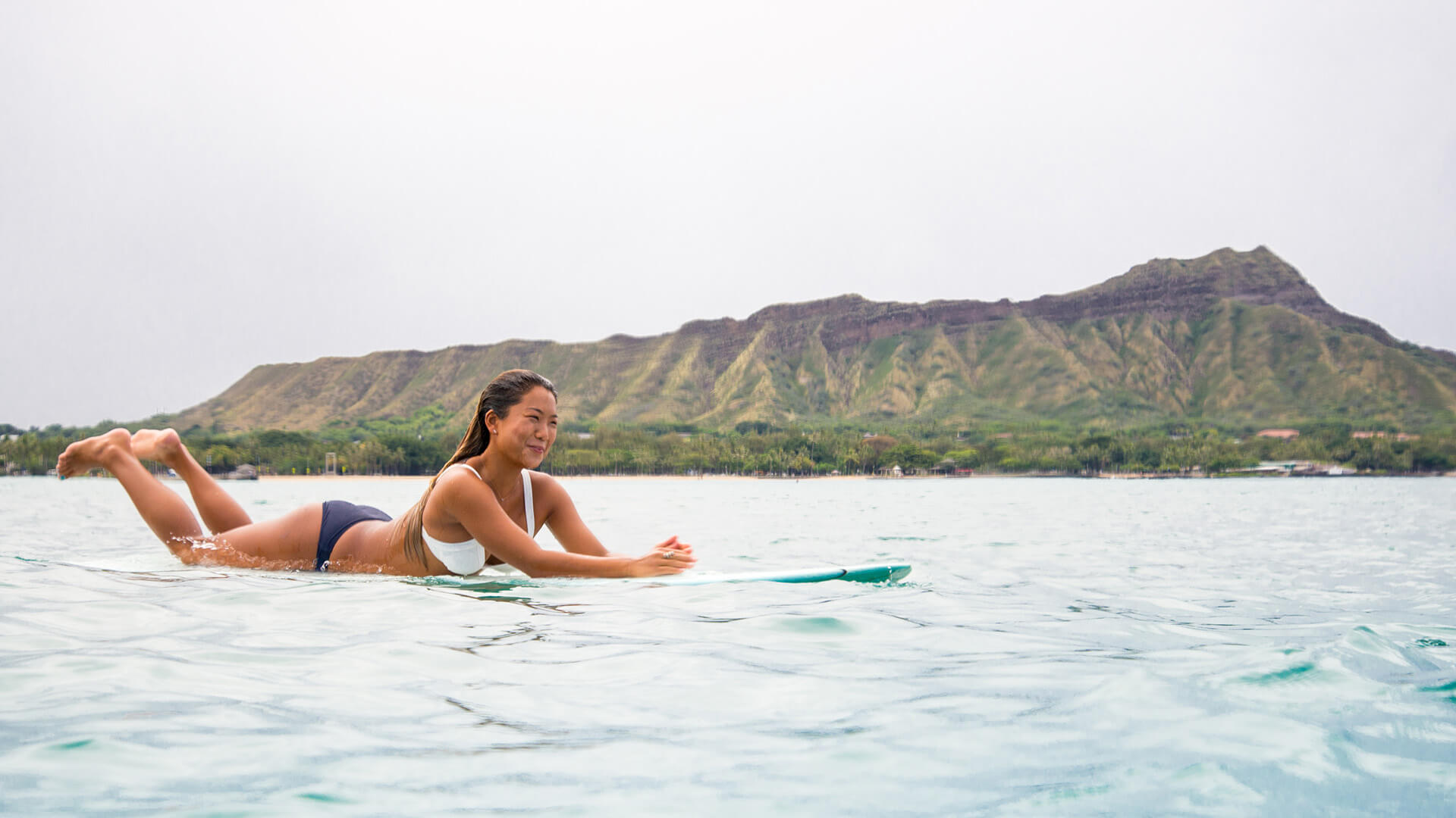 Woman on surfboard with Diamond Head in the background